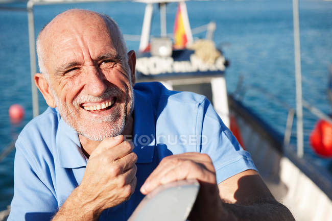 Ritratto del pescatore sorridente sulla barca da pesca — Foto stock