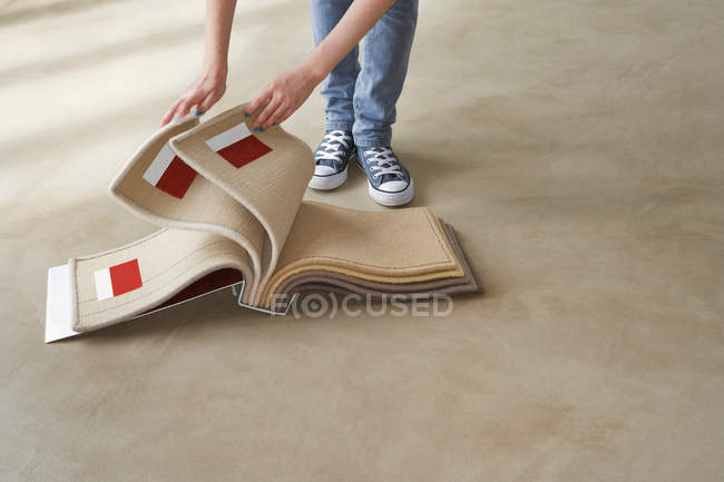 Обрізане зображення жінки, дивлячись на килимові зразки — стокове фото