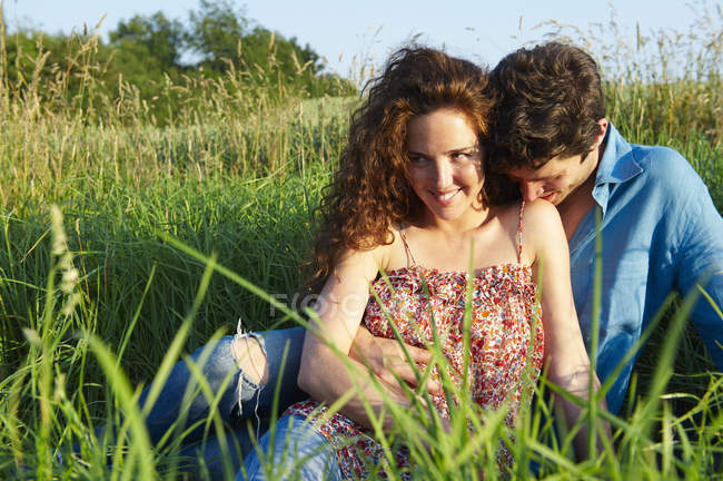 Couple sitting in a wheat field — Stock Photo