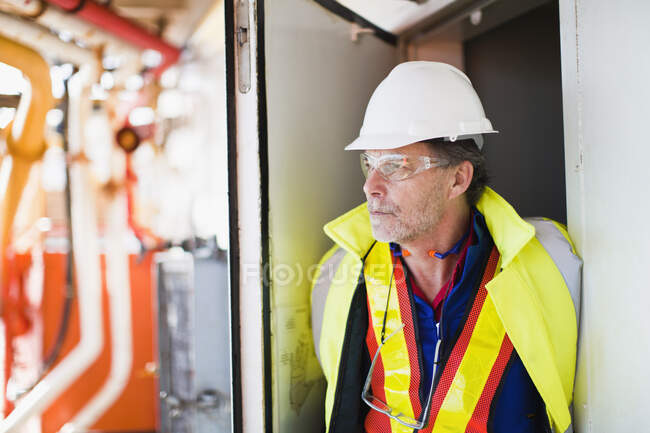 Trabajador de pie en la puerta de la plataforma petrolera - foto de stock