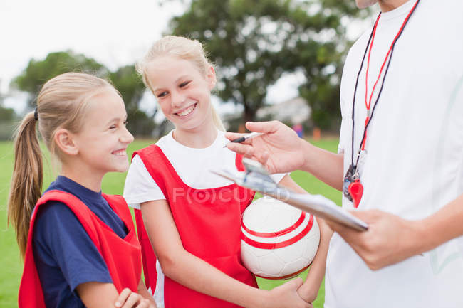 Treinador conversando com crianças na equipe de futebol — Fotografia de Stock