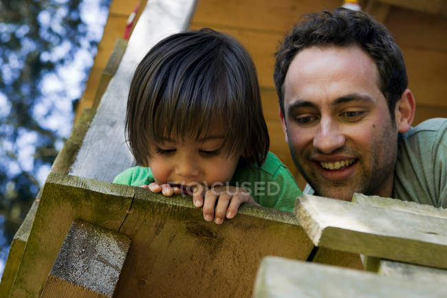 Father and son sitting in tree house — Stock Photo