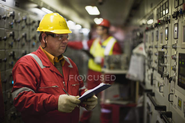 Worker checking machinery at plant — Stock Photo