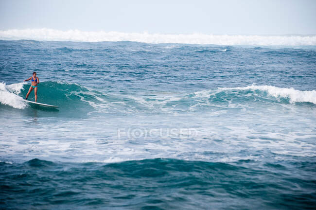 Серфер їде скелястими хвилями — стокове фото