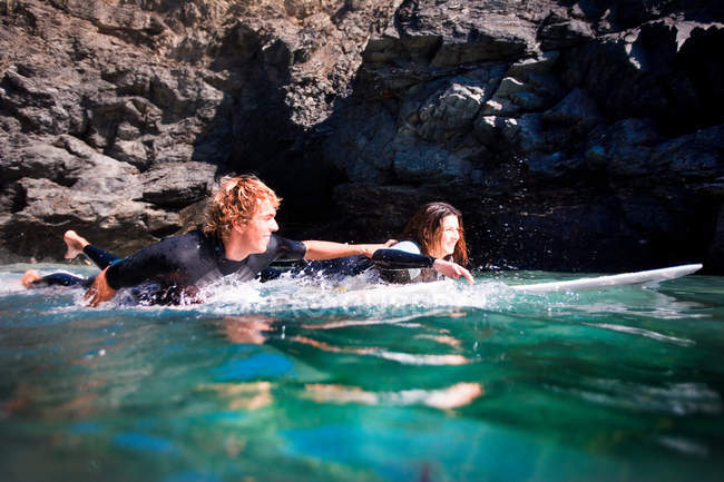 Paar liegt auf Surfbrettern im Wasser — Stockfoto