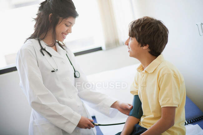 Женщина-врач осматривает пациента мальчика — стоковое фото