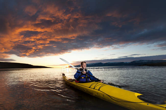 Mujer kayak en lago tranquilo, enfoque selectivo - foto de stock