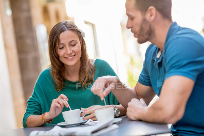 Пара має каву в тротуарному кафе — стокове фото