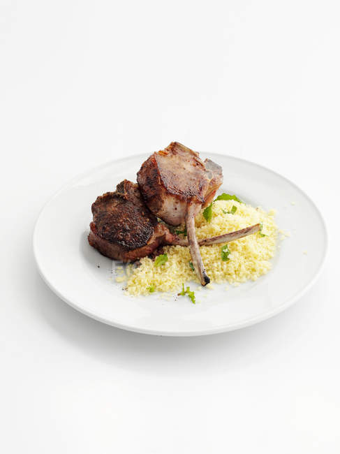 Lamb cutlet with couscous on plate — Stock Photo