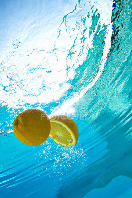 Lemon floating in swimming pool — Stock Photo
