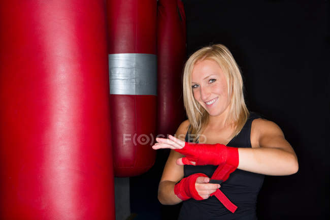 Boxerin wickelt ihre Hände im Fitnessstudio — Stockfoto