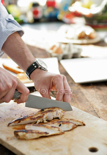 Man slicing chicken — Stock Photo