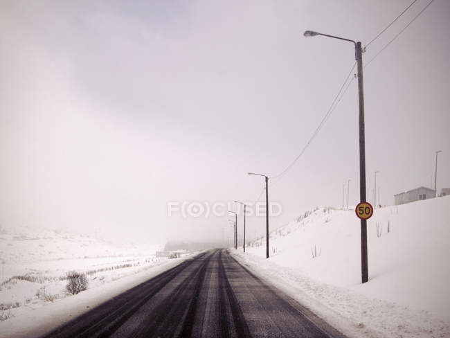 Straßenlaternen in verschneiter Landschaft — Stockfoto