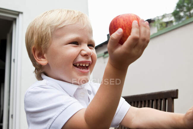 Menino segurando maçã em sua mão — Fotografia de Stock