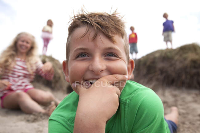 Портрет хлопчика з рукою на підборіддя посміхається, Уельс, Велика Британія — стокове фото