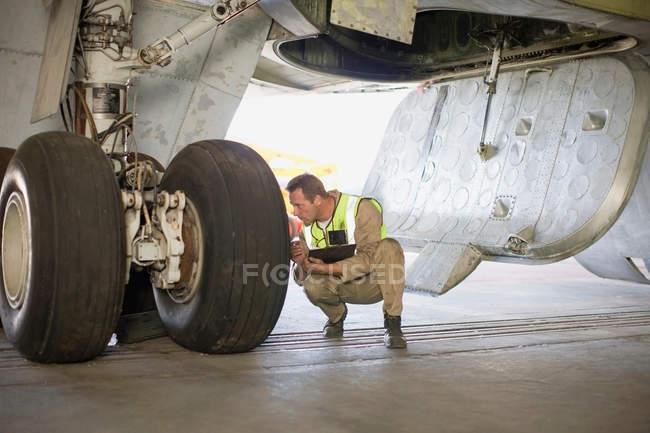 Trabalhador aeronáutico verificando avião — Fotografia de Stock