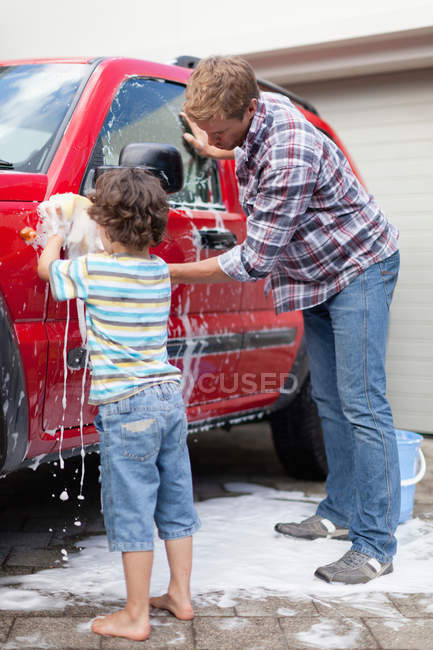 Father and son washing car together — Stock Photo