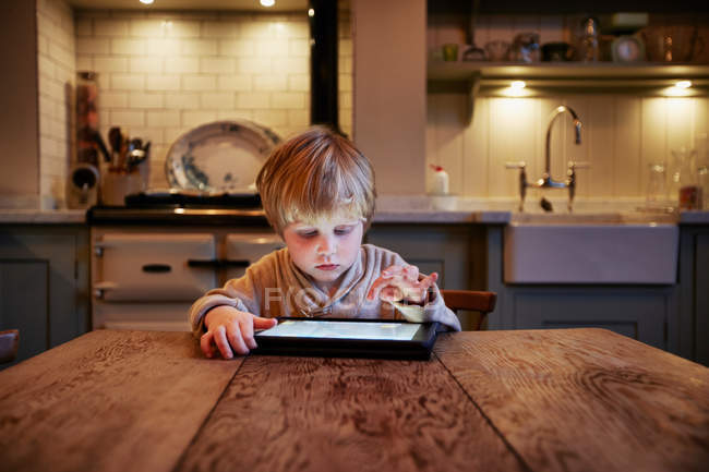 Junge benutzt Tablet-Computer am Tisch — Stockfoto