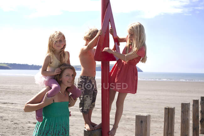 Mother with three children on beach, Wales, UK — Stock Photo
