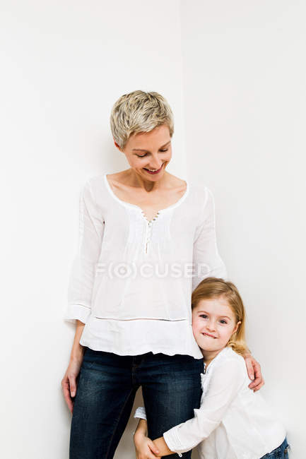 Sonriente madre e hija abrazándose - foto de stock