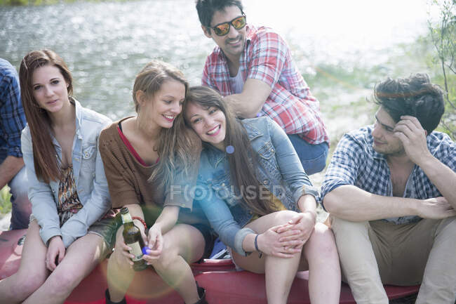 Group of six friends sitting on canoe — Stock Photo
