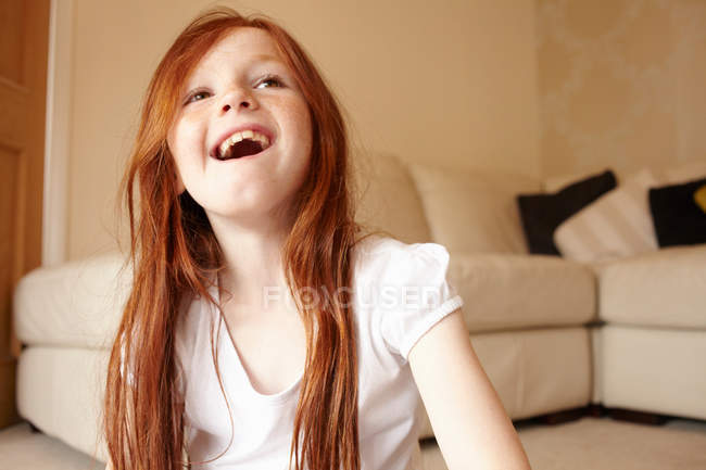 Lächelndes Mädchen auf dem Wohnzimmerboden — Stockfoto