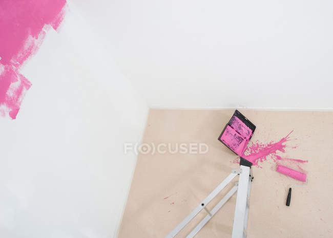 Top view of collapsed stepladder and spilt paint on wall and floor — Stock Photo