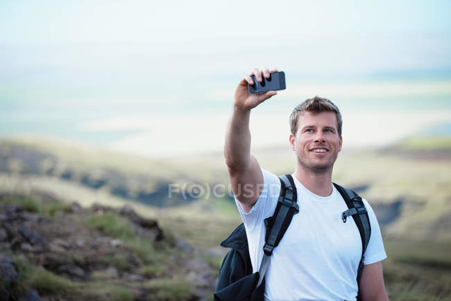 Hiker taking picture with cell phone — Stock Photo