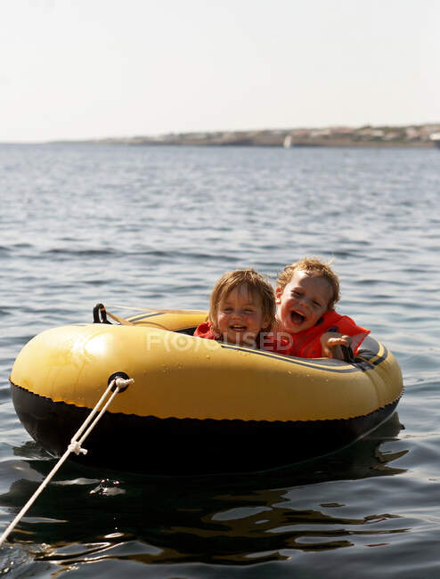Niños montando en bote inflable - foto de stock