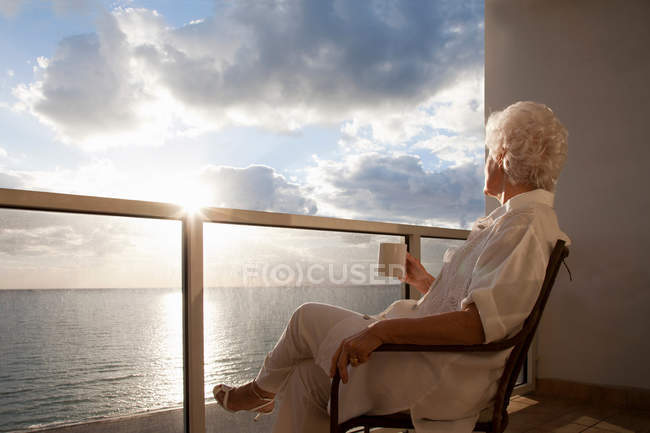Старша жінка дивиться схід сонця — стокове фото