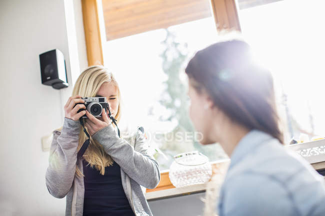 Дівчина-підліток фотографує друга з камерою — стокове фото