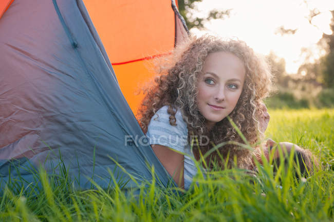 Ragazza adolescente sdraiata in tenda al campeggio — Foto stock