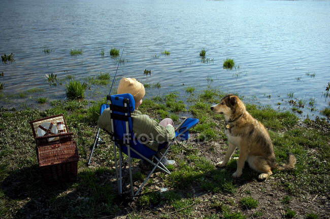 Ragazzo pesca con cane da compagnia — Foto stock