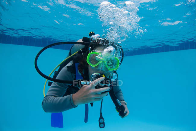 Femme pratiquant la plongée sous-marine en piscine — Photo de stock