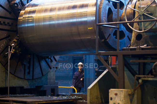 Worker with machinery in steel forge — Stock Photo
