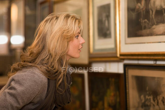 Woman looking up to painting — Stock Photo