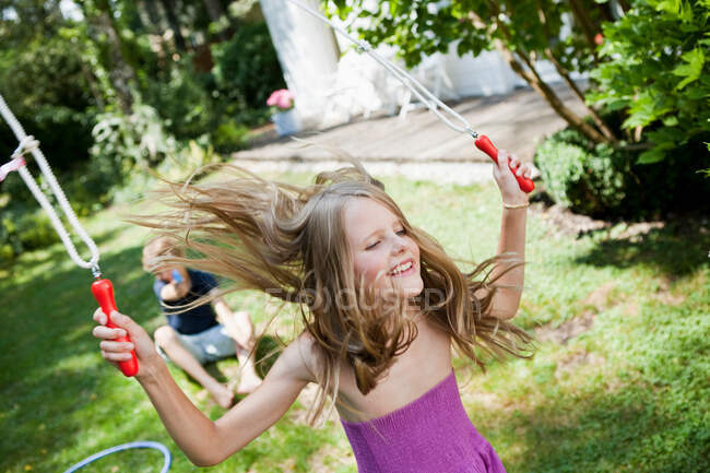 Дівчина стрибає мотузкою в саду — стокове фото