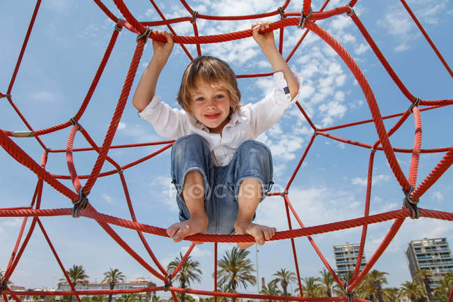 Boy playing on ropes on beach — Stock Photo