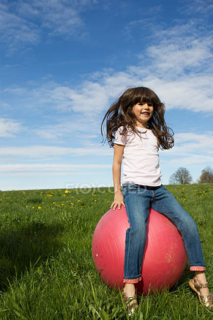 Girl playing on bouncy ball outdoors — Stock Photo