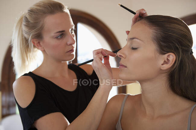 Maquiagem artista aplicando eyeliner ao modelo — Fotografia de Stock