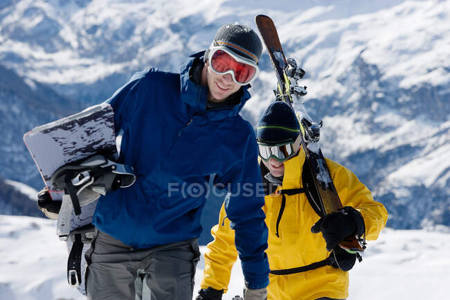 Male skier and male snowboarder walking — Stock Photo