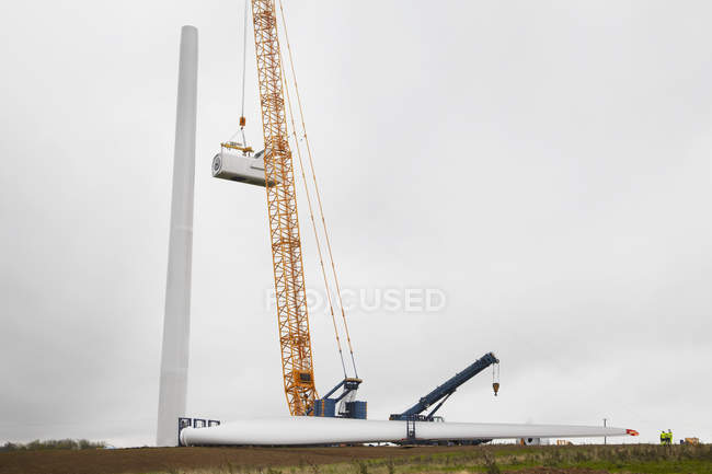 Gru e turbina con ingegneri che lavorano nel cantiere di parchi eolici — Foto stock