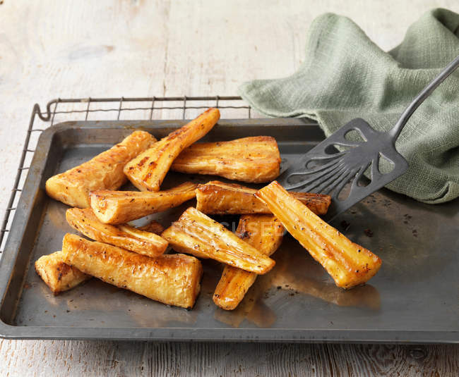 Honey roast parsnips on baking tray — Stock Photo