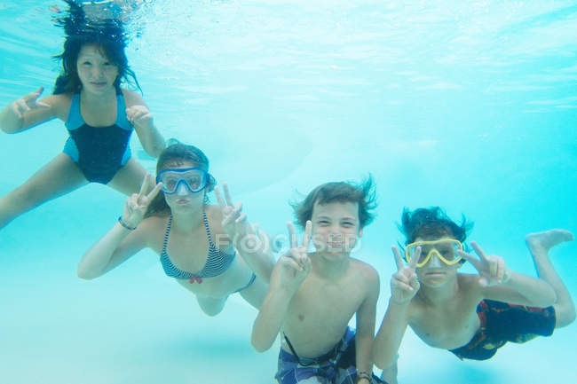 Bambini sorridenti che giocano in piscina — Foto stock