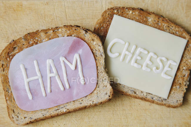 Vue du dessus des mots jambon et fromage écrits sur pain grillé à la mayonnaise — Photo de stock