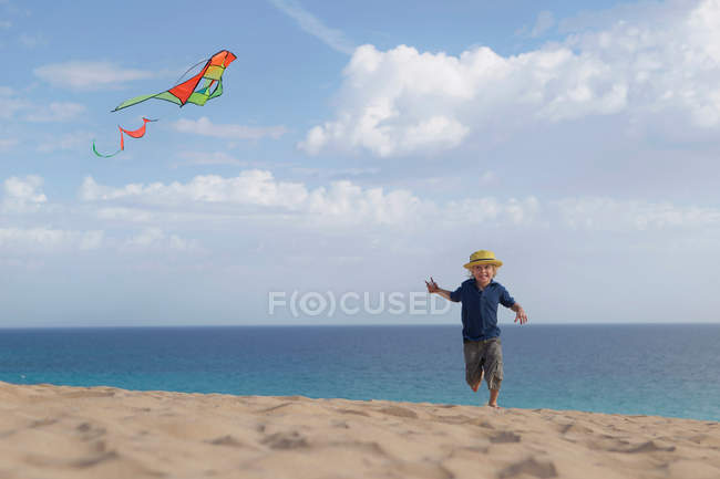 Junge fliegt Drachen am Strand — Stockfoto