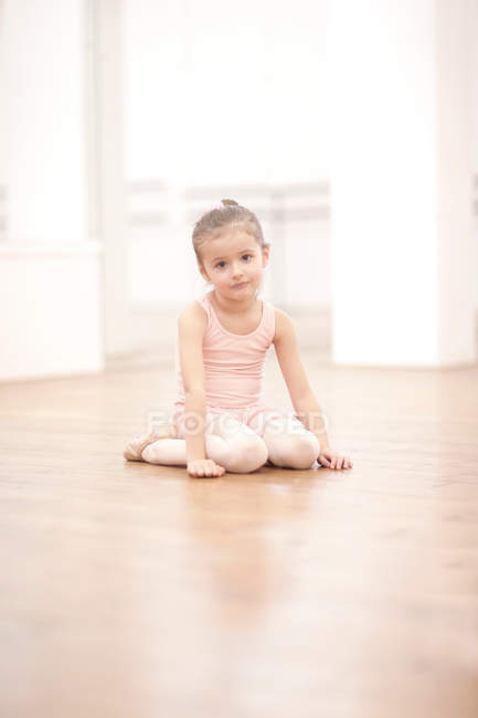 Portrait de jeune ballerine assise sur le sol — Photo de stock