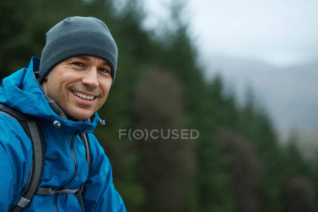 Homme en équipement de randonnée sur la colline — Photo de stock
