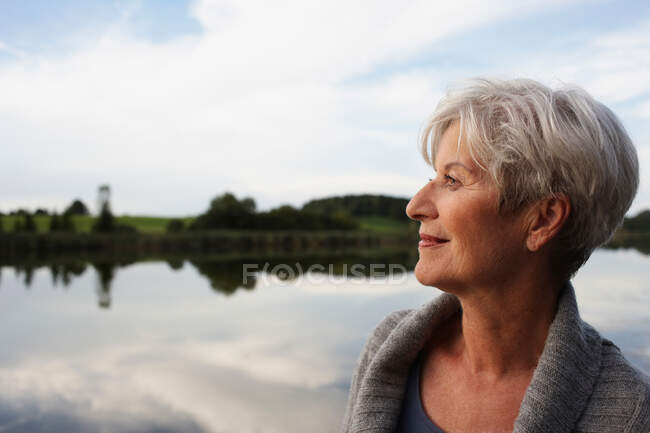 Donna anziana guardando il tramonto — Foto stock
