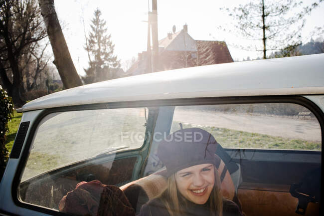 Menina sorrindo na parte de trás do carro — Fotografia de Stock